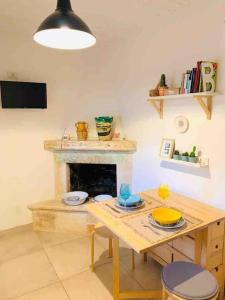 un soggiorno con tavolo e camino di Trullo Scirocco - Apulian House a Locorotondo