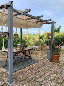patio con tavolo e ombrellone di Trullo Scirocco - Apulian House a Locorotondo