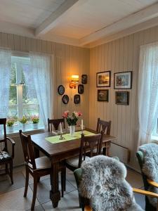 a dining room with a wooden table and chairs at Koselig feriehus, Birkedaltunet in Løvoll