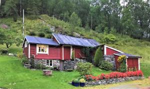 Koselig feriehus, Birkedaltunet في Løvoll: منزل احمر عليه لوحات شمسية