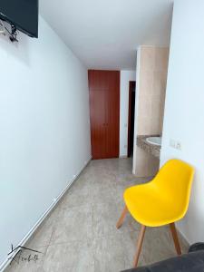 uma cadeira amarela num quarto com casa de banho em ACUBILLO em Palas de Rei