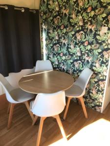 stół i cztery krzesła przed ścianą w obiekcie Stacaravan Jade w mieście IJmuiden
