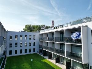 ein Apartmenthaus mit Rasen im Innenhof in der Unterkunft Apartament Słoneczny Piasek- A 147 z klimatyzacją- Solny Resort in Kołobrzeg