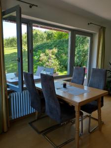een eettafel met stoelen en een groot raam bij Ferienhaus Keller in Lippertsreute