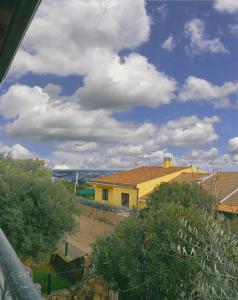 ein gelbes Haus mit blauem Himmel und Wolken in der Unterkunft Studio für 4 Personen ca 70 qm in La Ciaccia, Sardinien Anglona in Codaruina