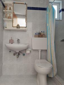 a bathroom with a toilet and a sink at Nefeli Apartments in Kefalos