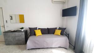 um quarto com uma cama com duas almofadas amarelas em Limited Edition Guesthouse em Bari