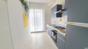 uma cozinha branca com um fogão e um lavatório em Limited Edition Guesthouse em Bari