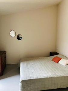 1 dormitorio con 1 cama y 2 luces en la pared en Domu in su satu, en Masainas
