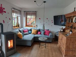a living room with a couch and a fireplace at Kuckucksnest - Ferienwohnung Welschneudorf in Welschneudorf