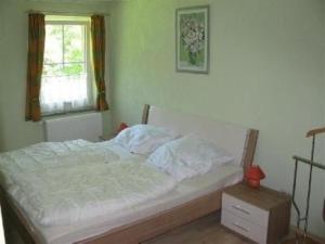 1 cama blanca en un dormitorio con ventana en Ferienwohnung für 4 Personen ca 37 qm in Sayda, Sachsen Osterzgebirge - a83556 en Sayda