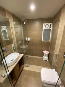 een badkamer met een wastafel, een toilet en een douche bij HOTEL EVERSHINE in Rajkot