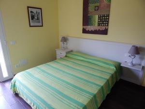 1 dormitorio con 1 cama con rayas verdes y azules en Il Melograno, en Albenga