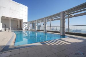 a large swimming pool on top of a building at Immaculate 1BR at Burj Al Nujoom Downtown Dubai by Deluxe Holiday Homes in Dubai