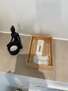 una caja de madera sentada en el suelo junto a una estatua en CPH Like Home en Copenhague