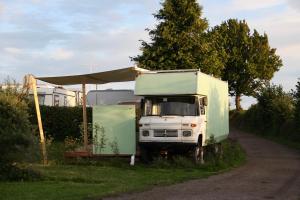 霍尔斯泰因地区诺伊斯塔特Marilyn - Glamping im Mercedes DüDo auf Camping Seeblick的停在路边的卡车