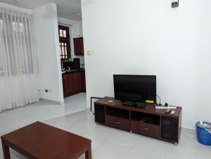 uma sala de estar com uma televisão de ecrã plano num centro de entretenimento em Homestay relax and enjoy em Sri Jayewardenepur- Kotte