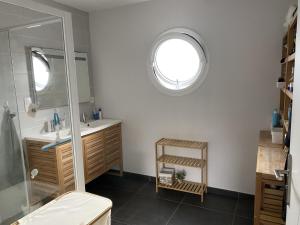 uma casa de banho com um chuveiro, um lavatório e um espelho. em Chambres 24h du Mans em Mulsanne