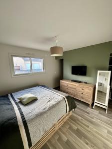 Chambres 24h du Mans في Mulsanne: غرفة نوم بسرير وتلفزيون بشاشة مسطحة
