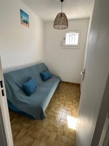 una sala de estar con un sofá azul en una habitación en Camargue Village Sun and Beach #2 5 Personnes, en Le Grau-du-Roi