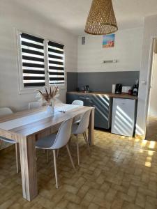 eine Küche mit einem Tisch und Stühlen sowie eine Küche mit einer Theke in der Unterkunft Camargue Village Sun and Beach #2 in Le Grau-du-Roi