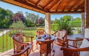 patio con mesa y sillas en el balcón en Ferienhaus mit Privatpool für 8 Personen ca 200 qm in Vrecari, Istrien Ostküste von Istrien, en Nedeščina