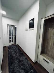 a hallway with a white wall and a door at Apartman Magnolia in Novi Pazar