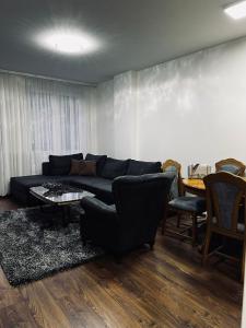 a living room with a couch and a table and chairs at Apartman Magnolia in Novi Pazar