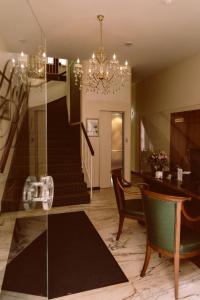 un salon avec un escalier et un lustre dans l'établissement Hotel Beek by Anna, à Baden-Baden