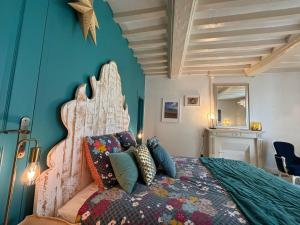 sypialnia z dużym łóżkiem z kolorowymi poduszkami w obiekcie B&B Nathalie w mieście Bayeux
