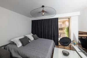 sypialnia z łóżkiem i wentylatorem sufitowym w obiekcie Somptueux appartement 20m plages avec vue mer w mieście Antibes