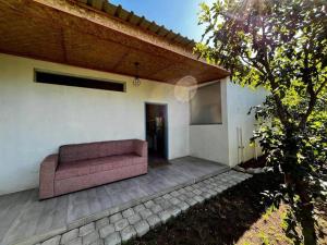 eine Couch auf einer Terrasse eines Hauses in der Unterkunft Charming Cottage in the wilderness on 5 Acres in Lusaka