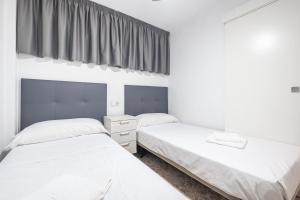 2 camas en una habitación con paredes blancas y ventana en Los Ranchos 1-3 Apartment Levante Beach, en Benidorm