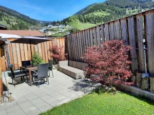a patio with a table and chairs and a fence at Chalet am Park in Piesendorf