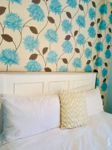 ein Schlafzimmer mit einem Bett mit blauen Blumen an der Wand in der Unterkunft The Westpoint Sandton Charm on 4th Floor in Johannesburg