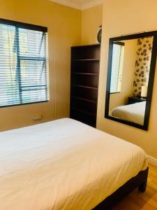Schlafzimmer mit einem Bett und einem Spiegel in der Unterkunft The Westpoint Sandton Charm on 4th Floor in Johannesburg