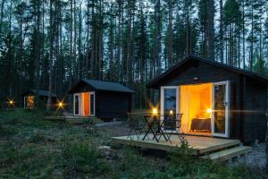 a cabin in the woods with a table and chairs at Utula Nature Retreat in Ruokolahti