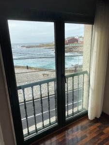 a room with a window with a view of the ocean at APARTAMENTO AUGAS DO COIDO in Muxia