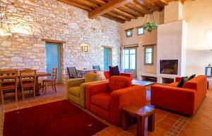 a living room with orange furniture and a stone wall at Luxury Villa Jolly in Paros Isterni in Isterni