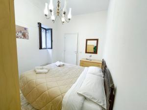 a bedroom with a bed and a chandelier at """ Holiday Properties Sicilian Central """ in Avola