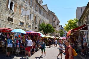 a group of people walking through a street market at Split It Hostel in Split
