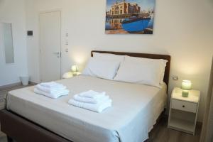 - une chambre avec un lit et des serviettes dans l'établissement BARI VICA ROOMS, à Bari