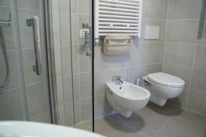 La salle de bains est pourvue de toilettes, d'un lavabo et d'une douche. dans l'établissement BARI VICA ROOMS, à Bari