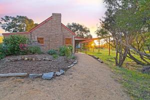 a brick house with a pathway leading to it at Blueberry Farm Cottage in Willunga