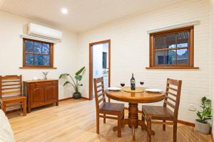 a dining room with a table and chairs at Blueberry Farm Cottage in Willunga +8 photos
