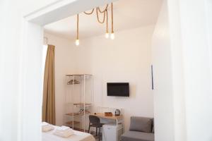 Cette chambre dispose d'un canapé, d'une table et d'une télévision. dans l'établissement BARI VICA ROOMS, à Bari