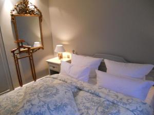 1 dormitorio con 1 cama grande y espejo en Ferienwohnung für 2 Personen ca 55 qm in Munkmarsch, Nordfriesische Inseln Sylt - a87454, en Munkmarsch