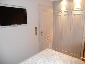 1 dormitorio con 1 cama y TV de pantalla plana en la pared en Ferienwohnung für 2 Personen ca 55 qm in Munkmarsch, Nordfriesische Inseln Sylt - a87454, en Munkmarsch