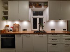 a kitchen with white cabinets and a sink and a window at Privacy within city limits in Tartu