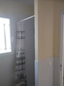 een badkamer met een douchegordijn en een raam bij Gîte Studioescos El Uno in Escos